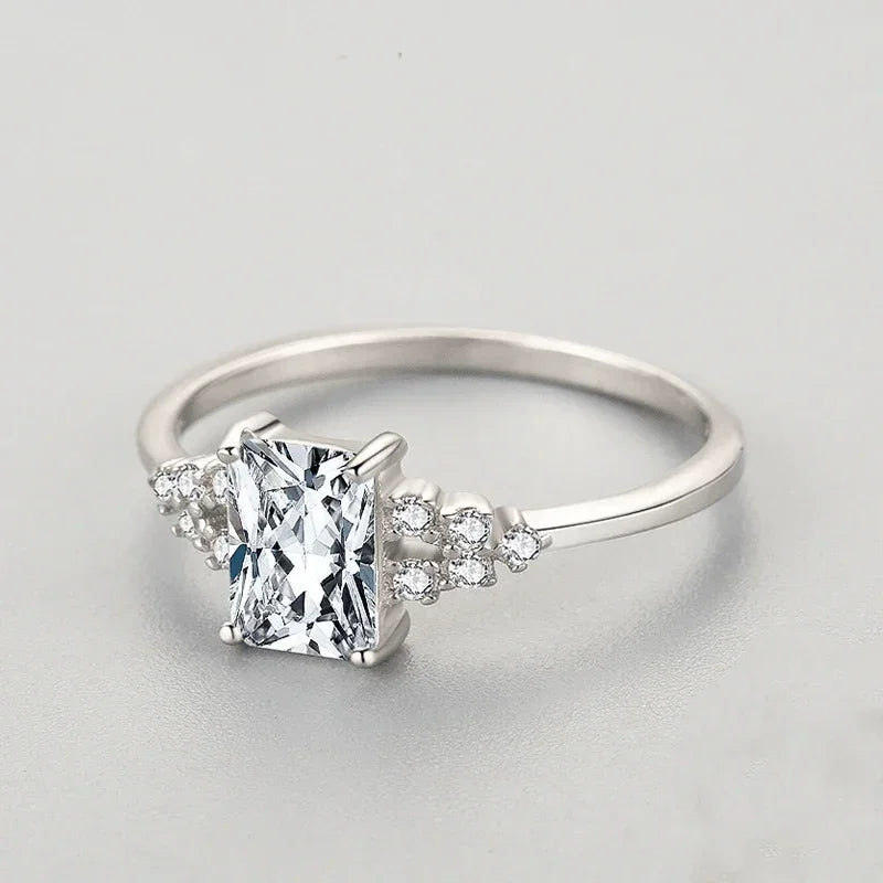 Sterling silver ring with rectangular clear stone and small accent crystals on band