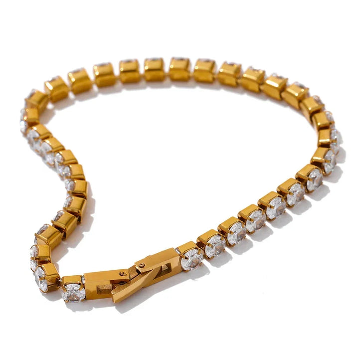 Gold bracelet with diamond accents on a white background