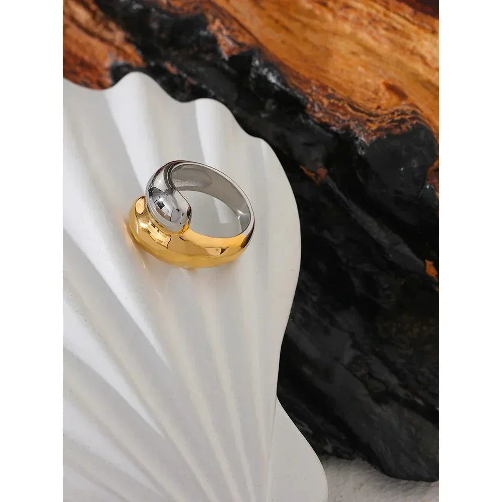 18K gold-plated and silver dome ring displayed on a white shell with dark wood background