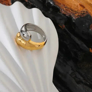 18K gold-plated and silver dome ring displayed on a white shell with dark wood background