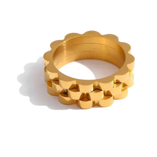 Stacked 18K gold-plated rings with scalloped edges on white background