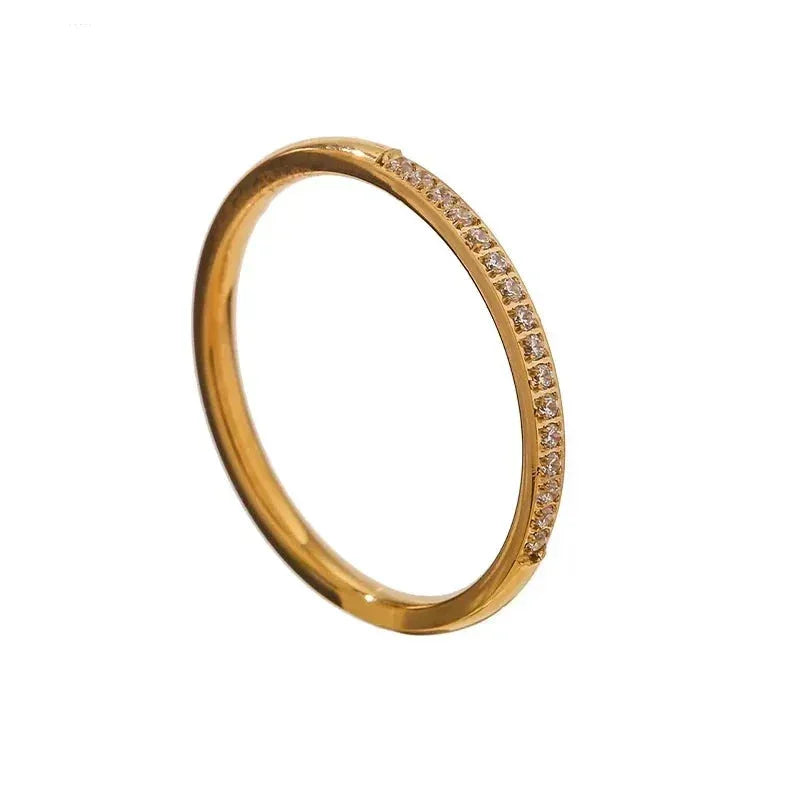 18K gold-plated slim ring with embedded sparkling stones on white background