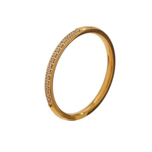 18K gold-plated slim ring with embedded sparkling stones on white background