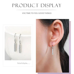 Silver earrings displayed on a white background and worn by a person.