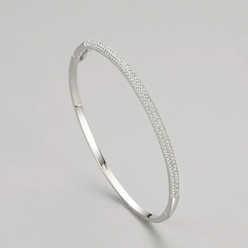 Elegant 925 silver bangle with pavé cubic zirconia on a plain light background