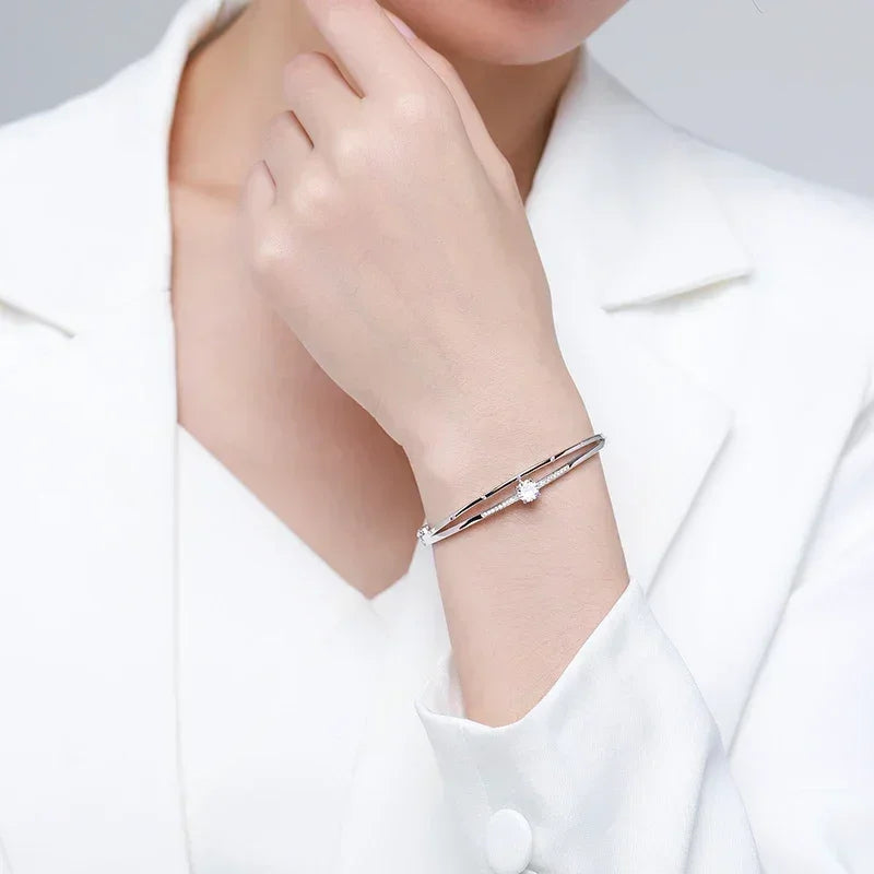 Woman wearing elegant silver double bangle bracelet with sparkling crystal accents