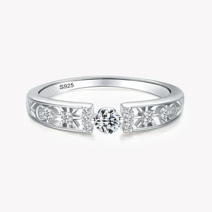 925 silver ring with central round diamond and side accent stones on filigree band.