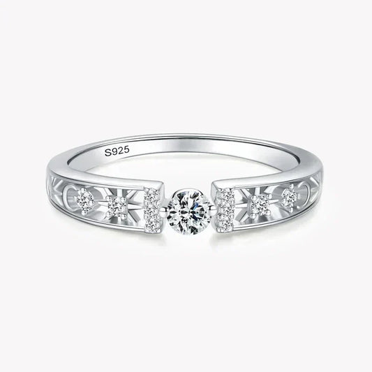 925 silver ring with central round diamond and side accent stones on filigree band.