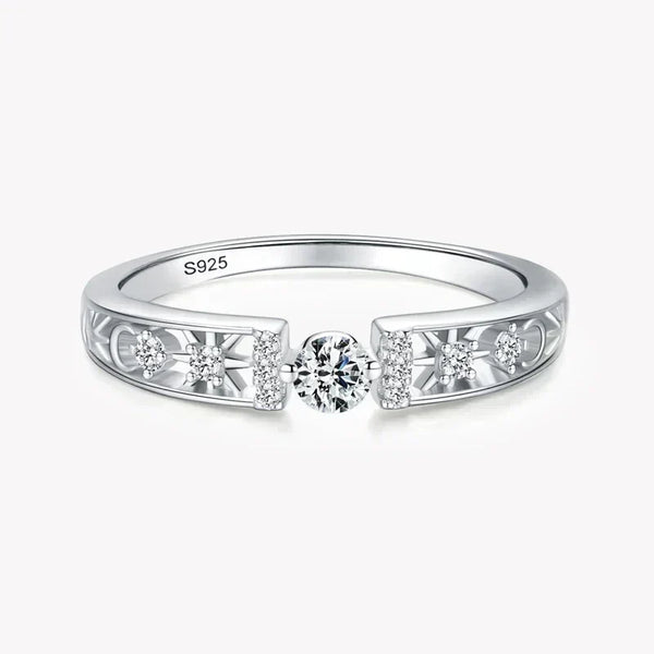 925 silver ring with central round diamond and side accent stones on filigree band.