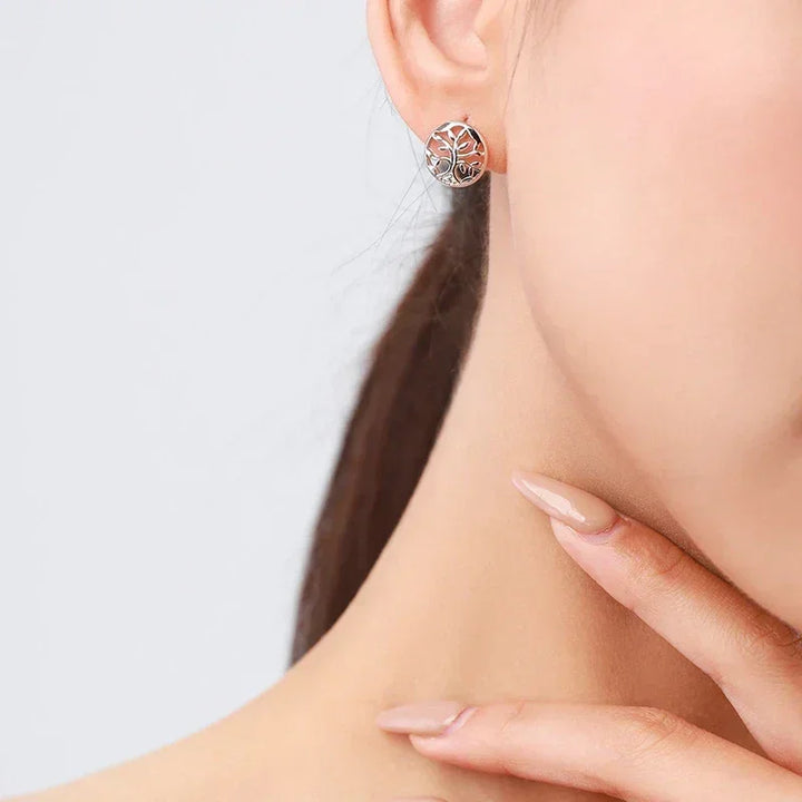 Woman wearing round 925 silver tree of life stud earring, minimalist jewelry