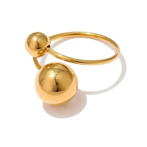 Gold ring with spherical ends on a white background