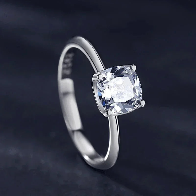 Sterling silver ring with cushion-cut clear gemstone on a dark background