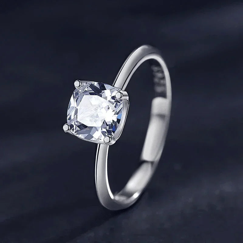 Sterling silver ring with cushion-cut clear gemstone on dark background