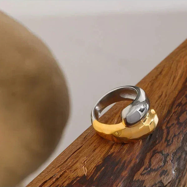 Chunky two tone ring in 925 sterling silver and 18K gold plating on wooden surface