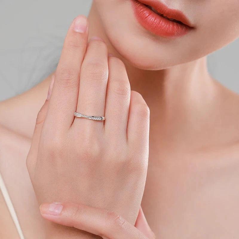 Woman wearing a delicate 925 silver ring with small sparkling stones on her finger