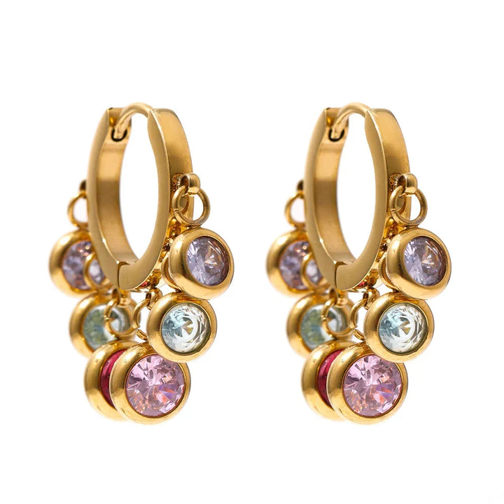 Gold hoop earrings with multicolored gemstones on a white background
