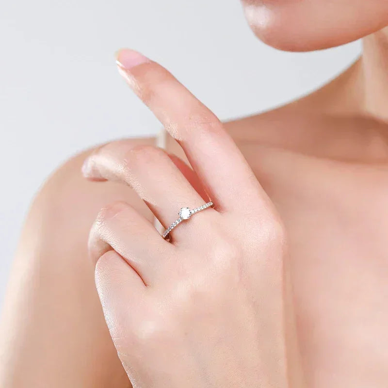 Elegant woman wearing a delicate 925 silver ring with a solitaire stone