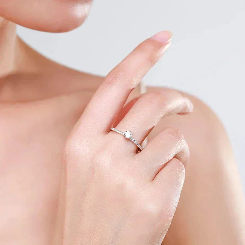 Woman wearing delicate 925 silver solitaire ring with small round gemstone