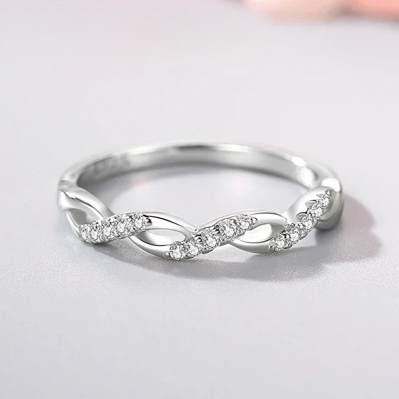 Sterling silver twisted ring with sparkling crystal accents on a light background