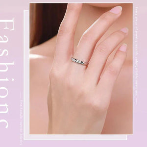 Silver ring on a hand with a soft pink background
