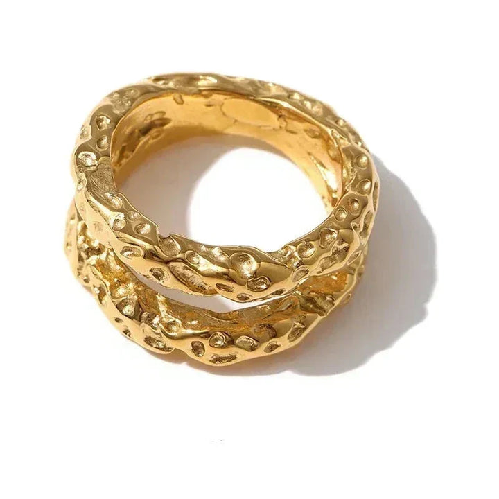 Gold ring with textured design on a white background