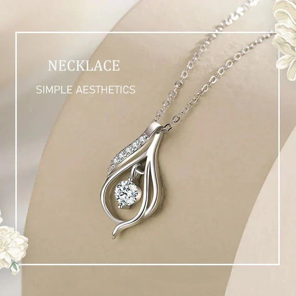Silver necklace with a decorative pendant on a neutral background