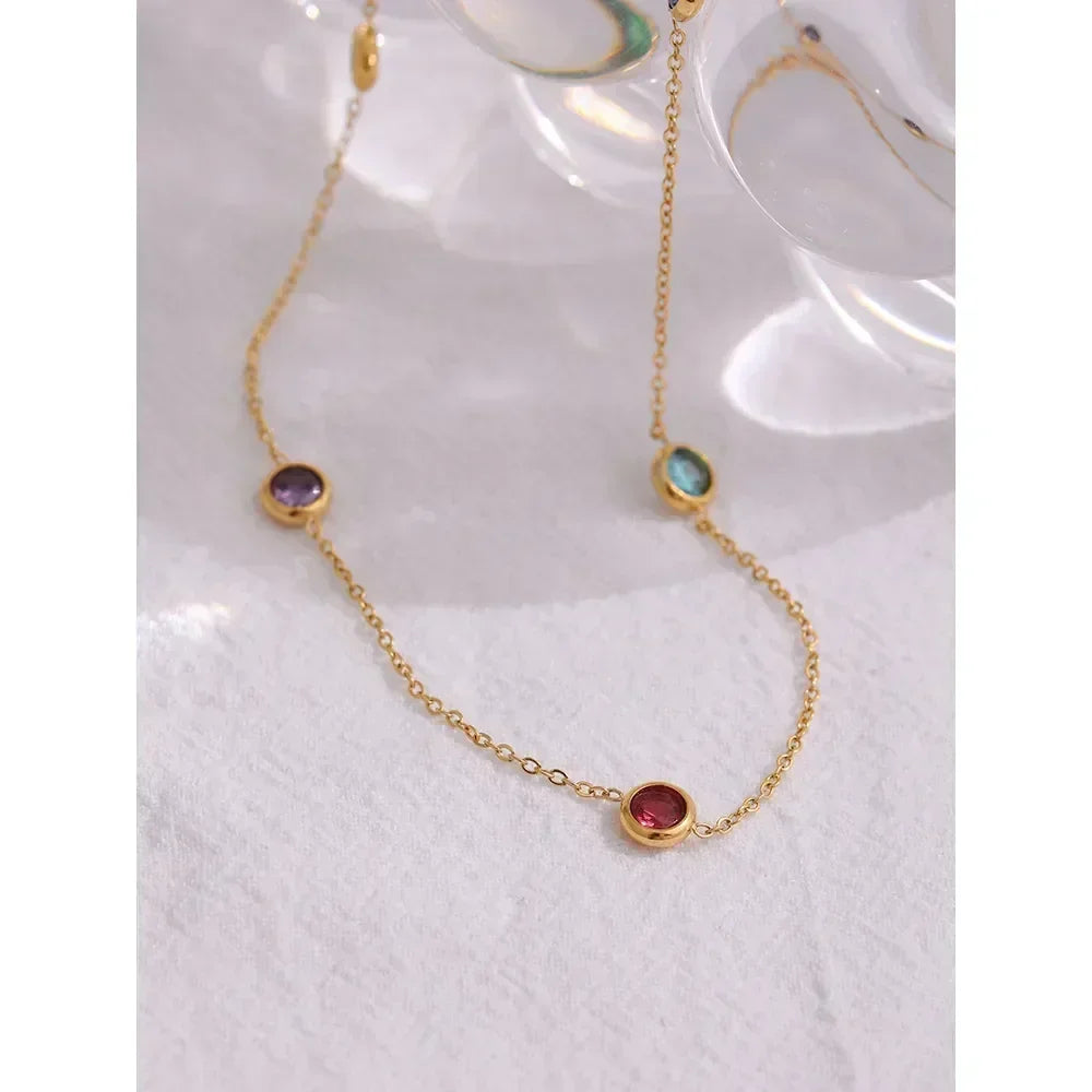 18K gold-plated chain necklace with colorful gemstone bezels on a light background