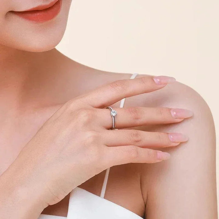 Woman wearing a silver solitaire ring with clear gemstone on her hand