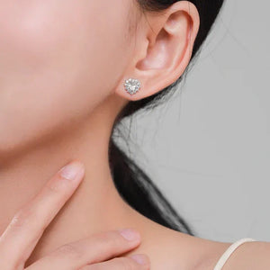 Heart-shaped earring worn by a person with a neutral background