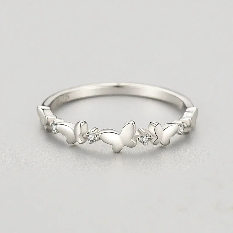 Sterling silver butterfly ring with small round gemstones on a plain background