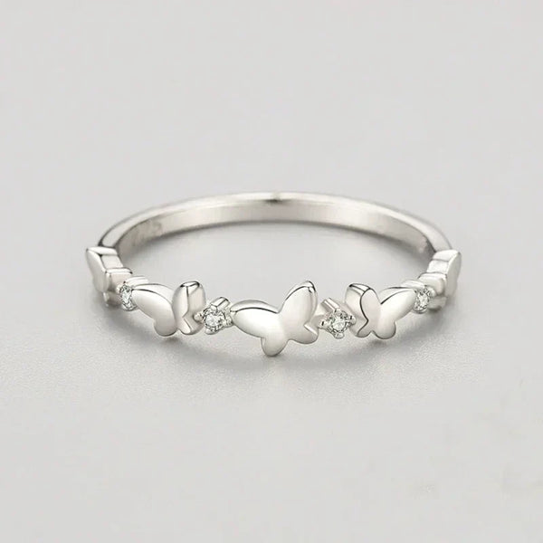 Silver butterfly ring with small diamonds on a light gray background