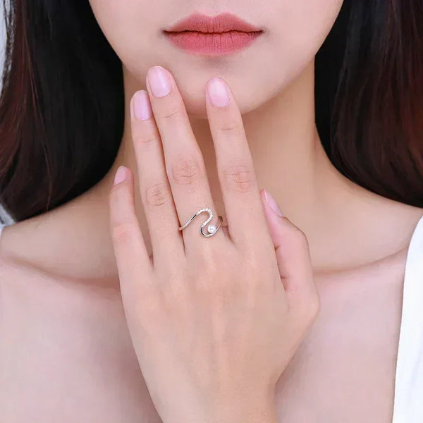 Woman wearing an elegant silver snake-shaped ring with cubic zirconia accents