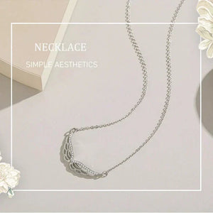 Silver necklace on a light background with decorative flowers.
