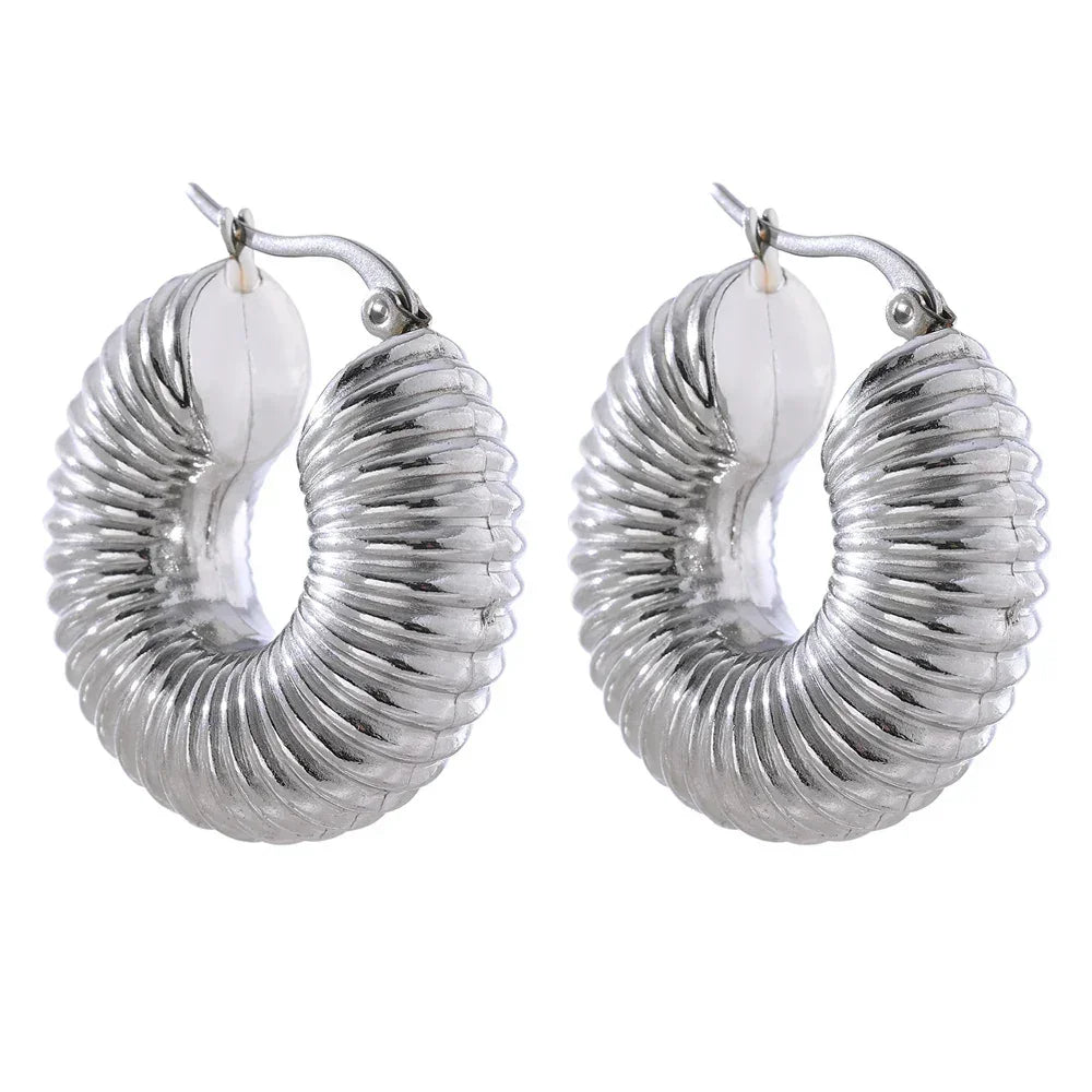 Ribbed chunky 925 silver hoop earrings with a bold curved design on white background