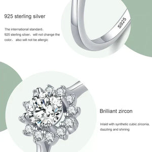 Silver ring with zirconia stones and '925 sterling silver' text on a light green background