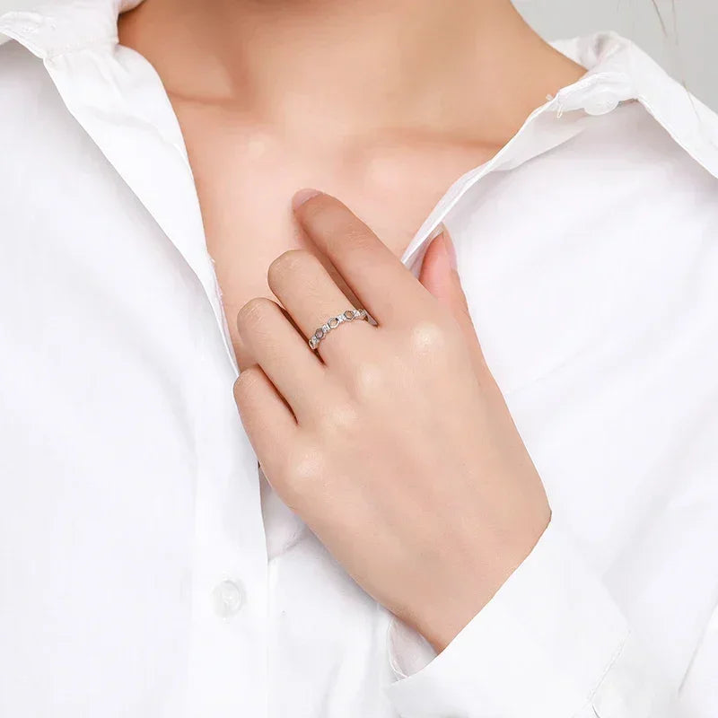 Woman wearing a 925 silver gemstone ring with a white shirt, elegant jewelry close-up