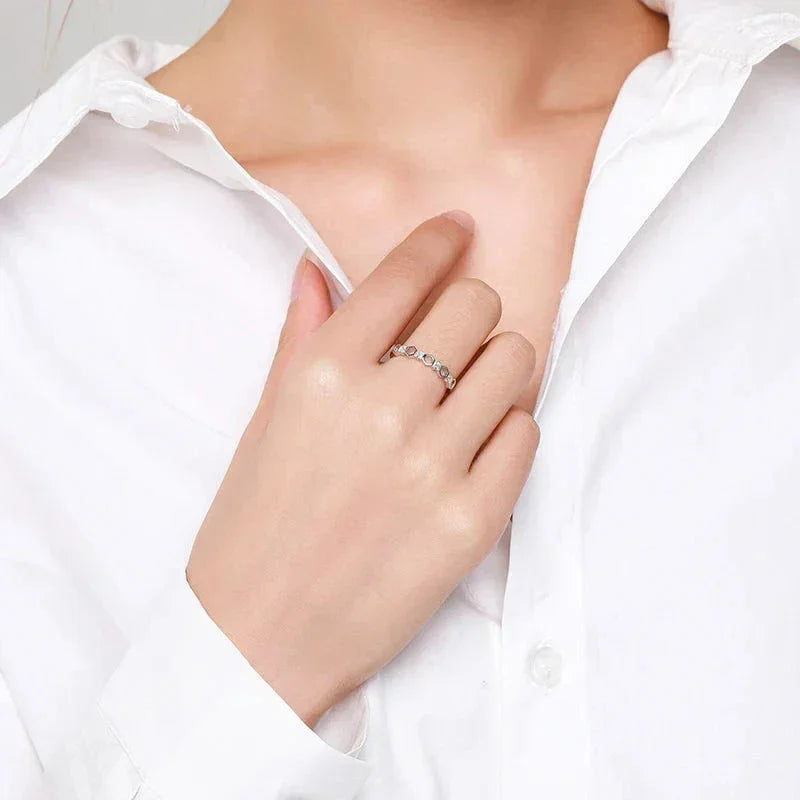 Woman wearing a silver gemstone ring on hand, styled with a white shirt, jewelry closeup