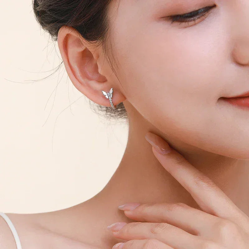 Close-up of woman wearing butterfly-shaped sterling silver stud earring