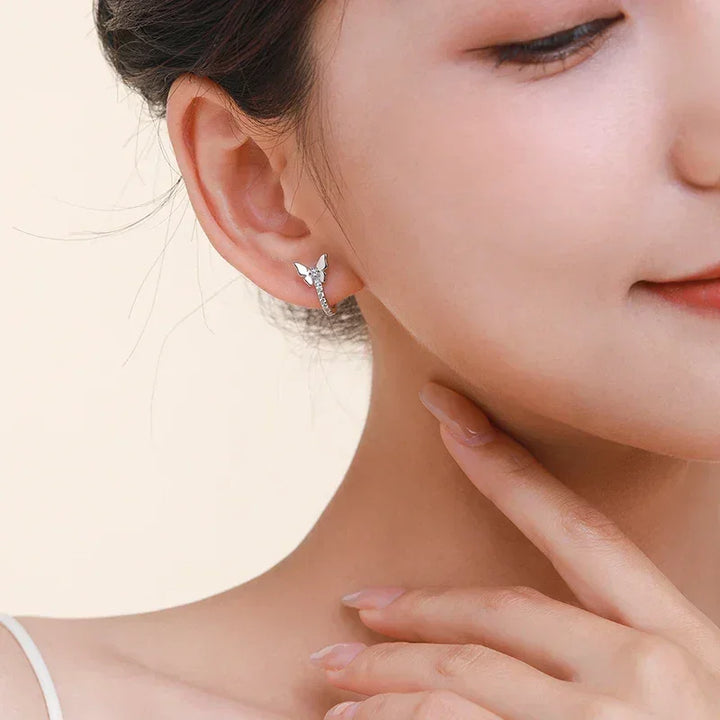 Close-up of woman wearing butterfly-shaped sterling silver stud earring