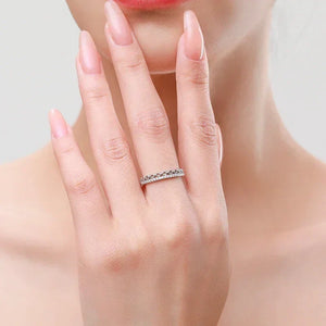Woman wearing a silver band ring with cubic zirconia on her finger, elegant jewelry style