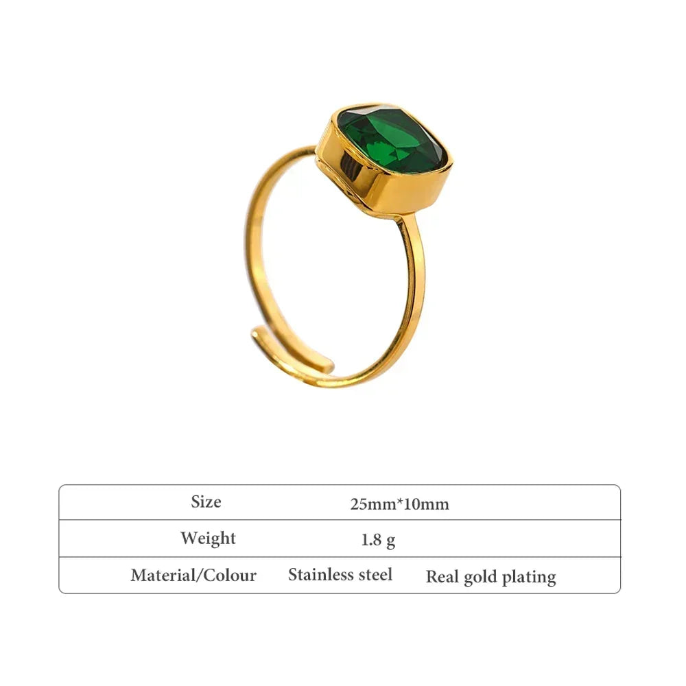Gold-plated open ring with green gemstone on white background, stainless steel jewelry.