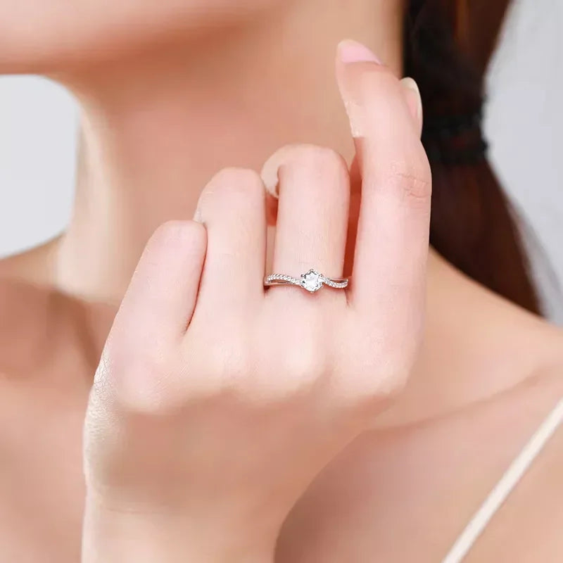 Woman wearing elegant 925 silver solitaire engagement ring with round gemstone