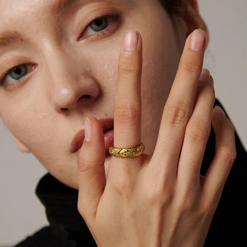 Close-up of a person wearing a gold ring on their finger.