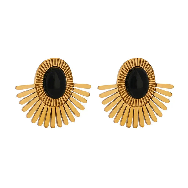 Pair of gold earrings with black centers on a white background