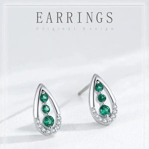 Teardrop-shaped earrings with green gemstones on a white background
