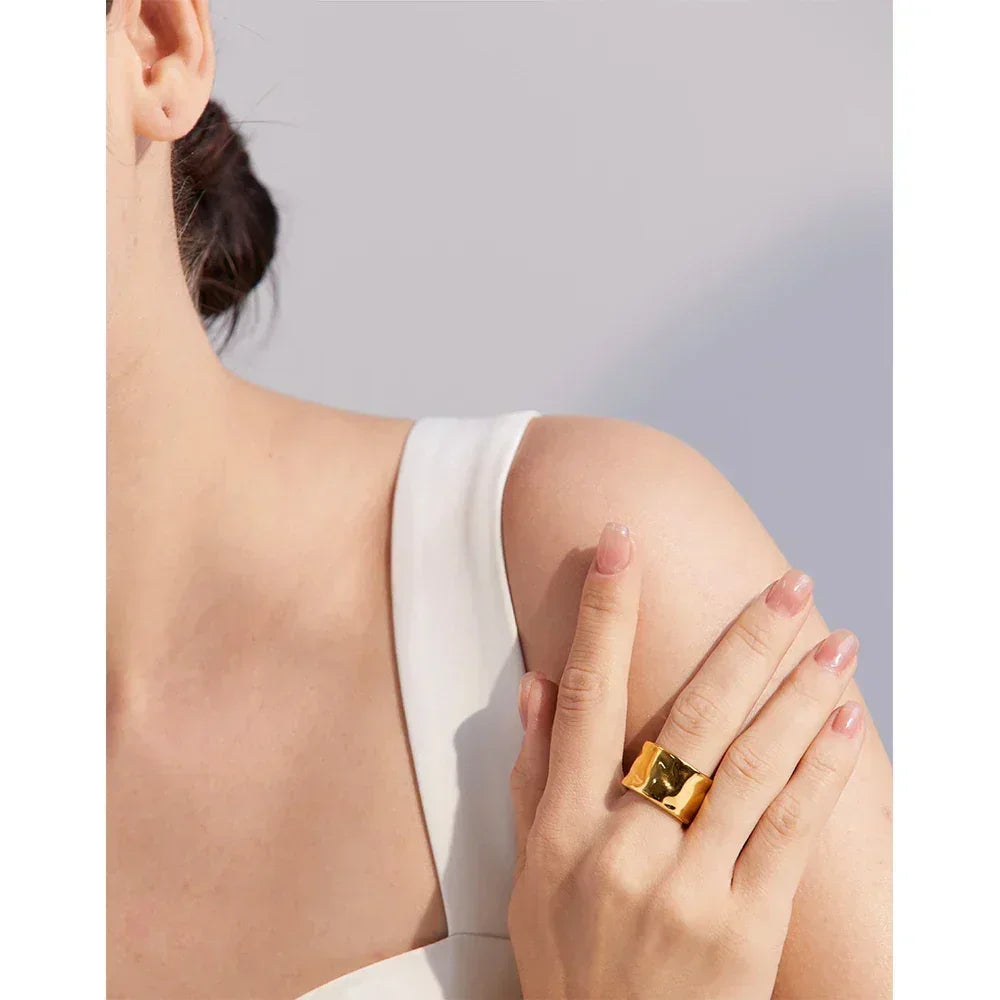 Woman wearing chunky 18K gold-plated ring on finger, elegant minimalist jewelry style
