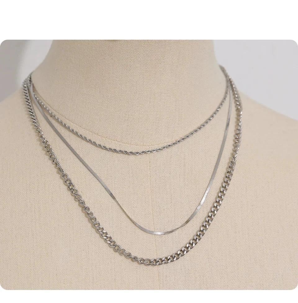 Three layered 925 silver chain necklaces displayed on a beige mannequin bust.
