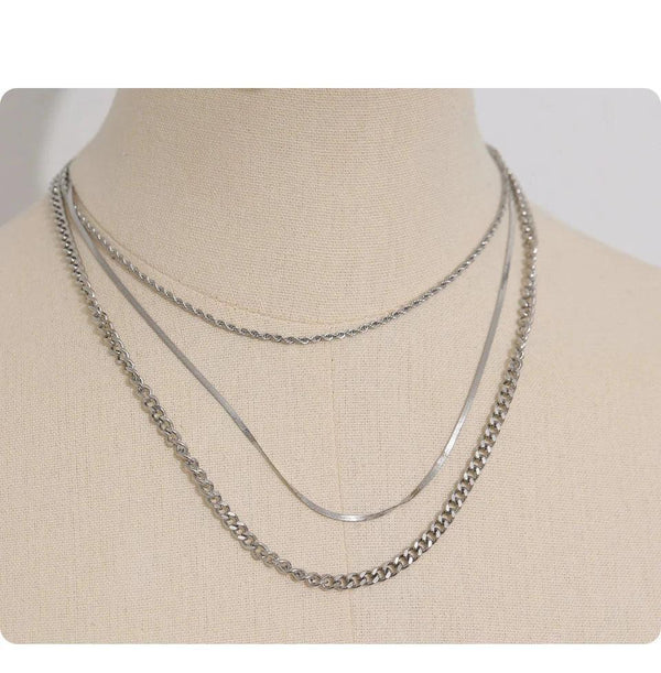 Three layered 925 silver chain necklaces displayed on a beige mannequin bust.