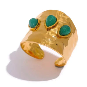 Gold ring with turquoise stones on a white background
