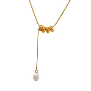 Gold necklace with three gold beads and a pearl pendant on a white background